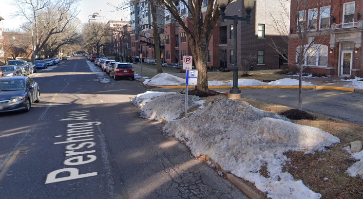 A bus stop in a dense area that puts riders in the driving lane